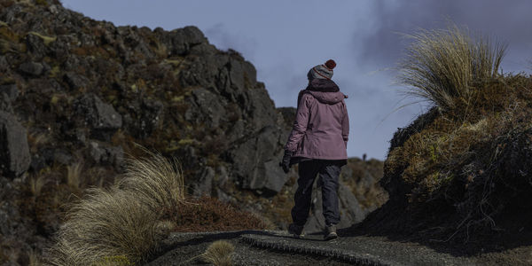 Rear view of a person walking on a pathway in  rugged terrain