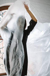 Woman wrapped in plastic at home
