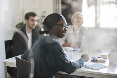 Businesswoman smiling while sitting in board room during business meeting