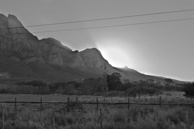 Scenic view of field and mountains against sky