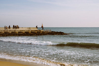 People on beach against sky