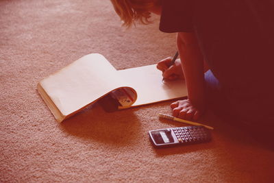 Cropped image of boy drawing in book at home