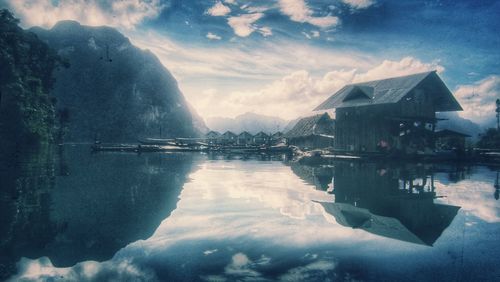 Scenic view of lake by mountains against sky