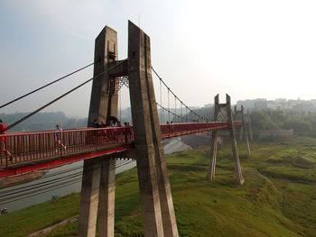 Low angle view of suspension bridge against sky