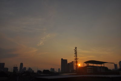 Silhouette buildings against sky during sunset