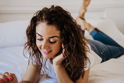 Smiling woman lying on bed at home