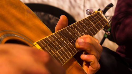 Midsection of man playing guitar