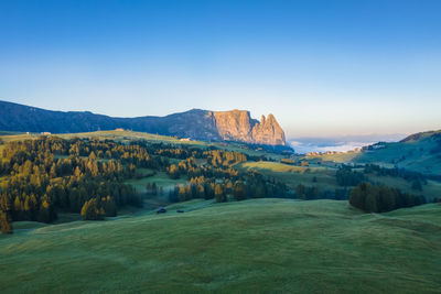 Scenic view of landscape and mountains against clear blue sky