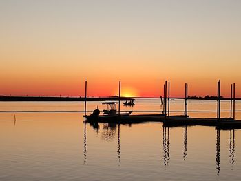 Silhouette sailboat in sea against sky during sunset