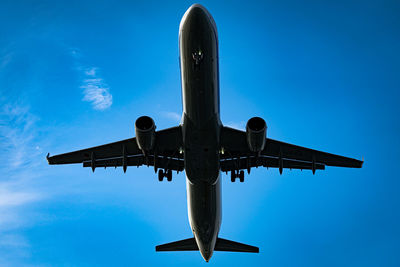 Low angle view of airplane flying against sky