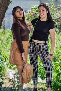 A beautiful latin girls smiling and walking in the city park, garden with many plants