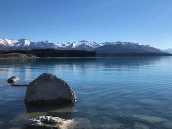 Scenic view of lake and snowcapped mountains against sky