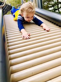 Cute boy plying on slide in playground