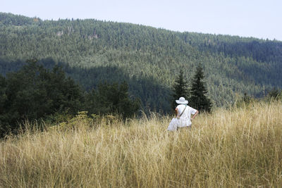 Full length of woman on field in dry grass