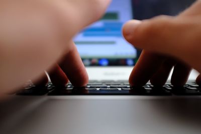Close-up of man using laptop