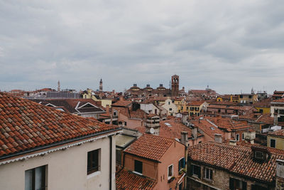 Houses in town against cloudy sky