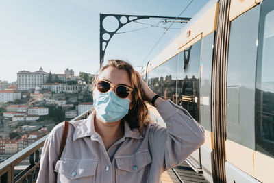 Portrait of young woman standing in train