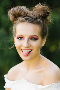 A cheerful funny young woman or girl with bright makeup and a funny hairstyle squinted one eye