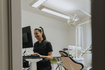 Female dentist using computer in office