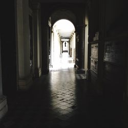 Narrow corridor leading towards archway