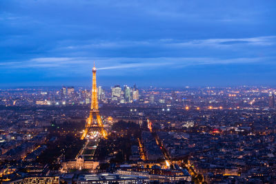 Illuminated buildings in city against sky