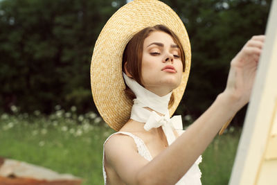 Young woman wearing hat standing outdoors