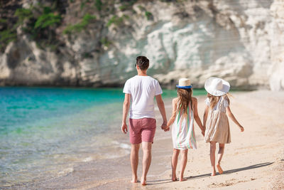 Rear view of couple walking on beach