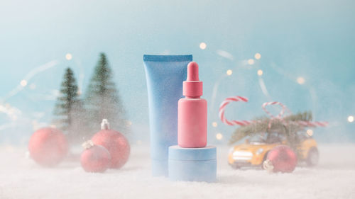 Mockup jars of cosmetic products on a christmas background with falling snow. gift for the new year.