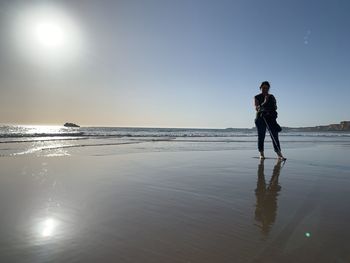 Man standing on beach against sky