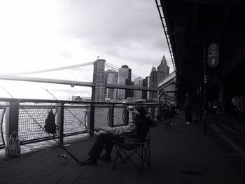 Bridge over river against cloudy sky