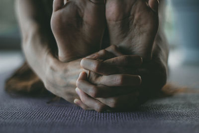 Low section of woman doing yoga at home