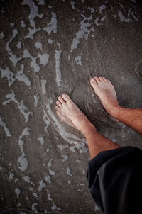 Low section of person on sand at beach