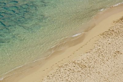 High angle view of beach with footsteps 