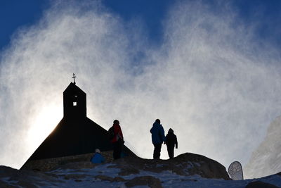 Low angle view of people in front of building against sky