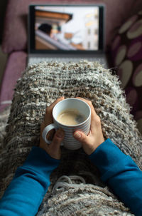 Midsection of person holding coffee cup