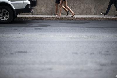 Low section of woman walking on road