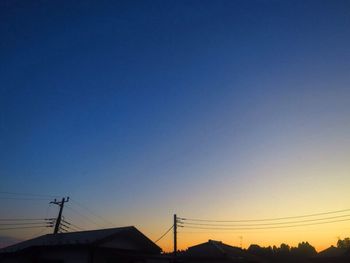 Low angle view of silhouette roof against clear sky