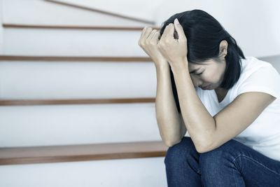 Midsection of woman sitting on wall