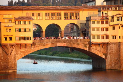 People at ponte vecchio over river