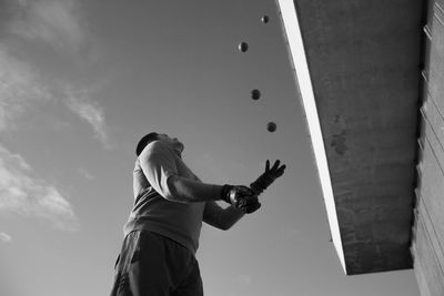 Low angle view of man playing with balls