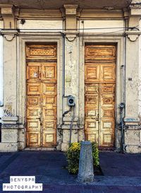 Man standing against door of building