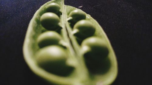 Close-up of green chili pepper against black background