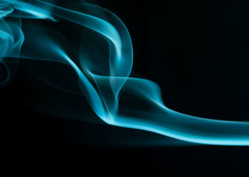 Close-up of blue light painting against black background