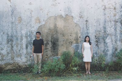 Portrait of young woman standing on wall