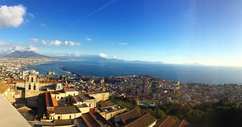 High angle view of town by sea against sky