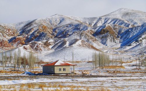 Snow covered houses and buildings against sky