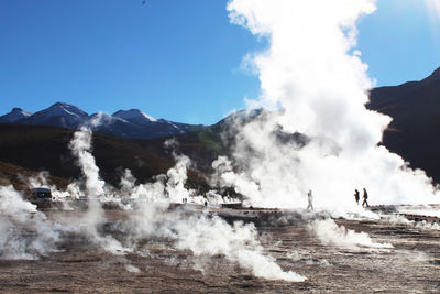 Scenic view of volcanic mountain against sky during sunny day