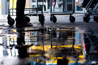 Low section of man standing by shopping carts