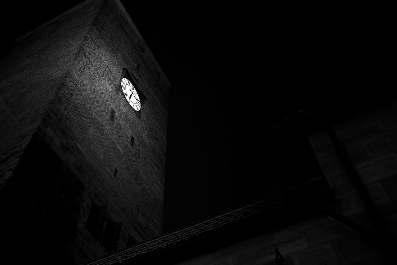 LOW ANGLE VIEW OF ILLUMINATED CLOCK TOWER AGAINST BUILDING