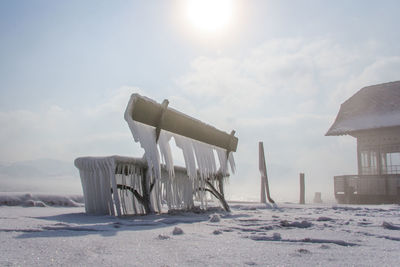 Built structure on snow covered land against sky